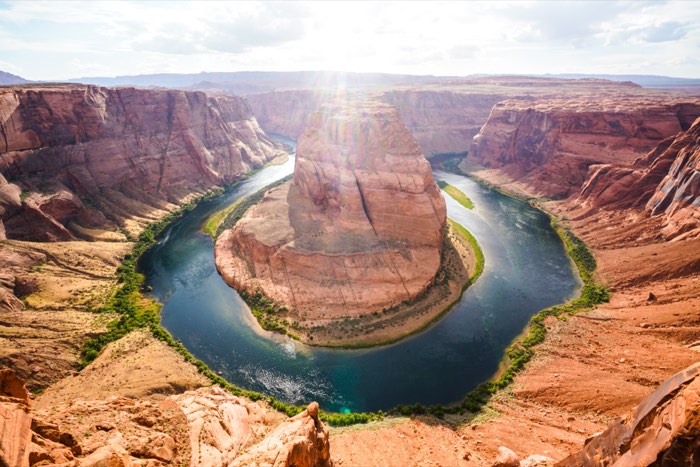 The Colorado River looping around a sandstone horseshoe.